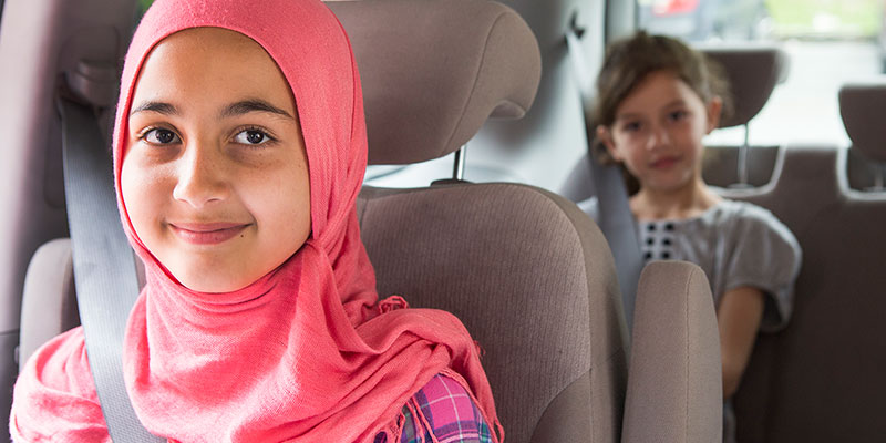 Young woman in a car with a child in the back seat